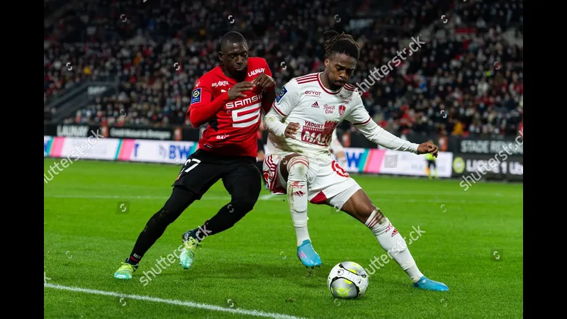 Cầu thủ Rennes đi bóng qua cầu thủ Brest trong trận đấu sôi động.